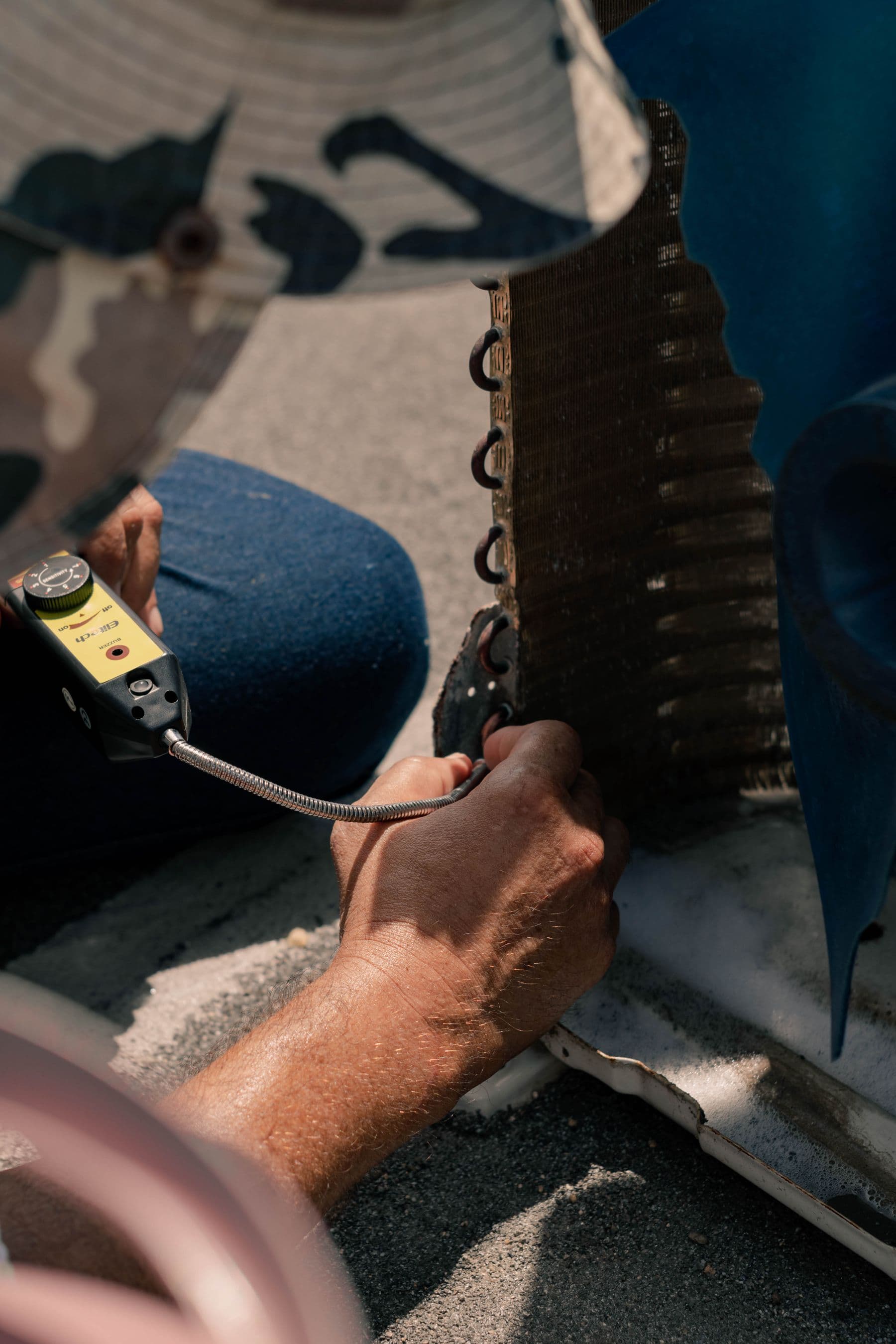 Technician checking an air conditioning coil with a service tool